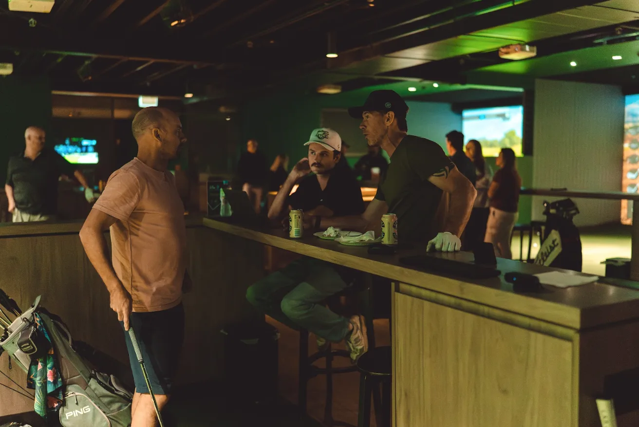 Members chatting at the bar between sessions at GolfSpace