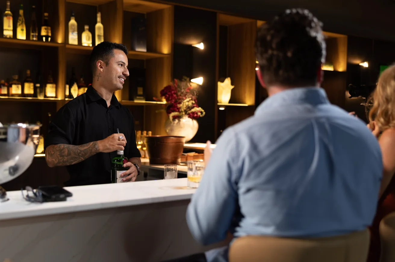 Bartender serving members at The Reserve bar