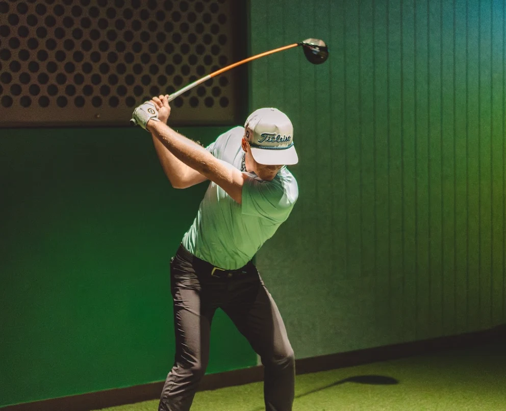 Member mid-swing in a GolfSpace TrackMan bay